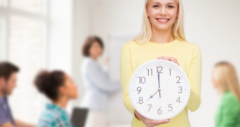 student smiling holding clock