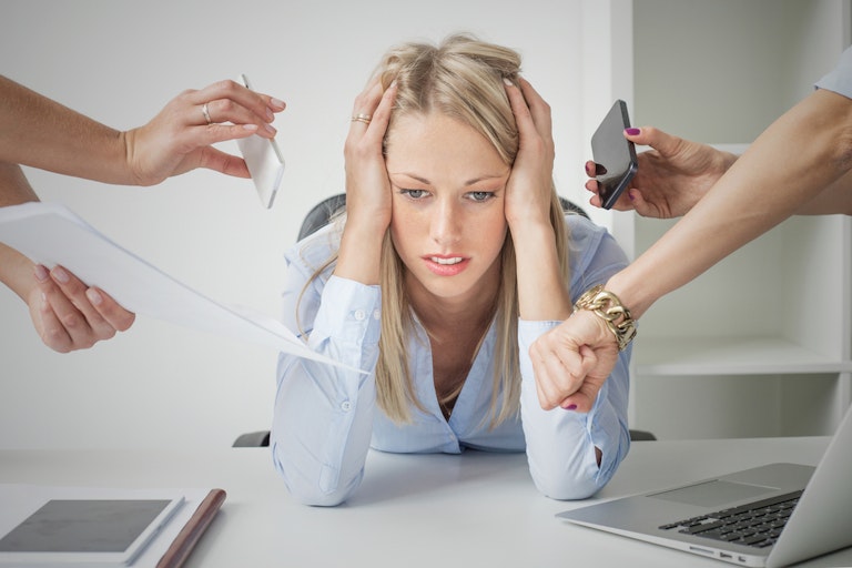 Woman looking stressed out while people around her are telling her what to do